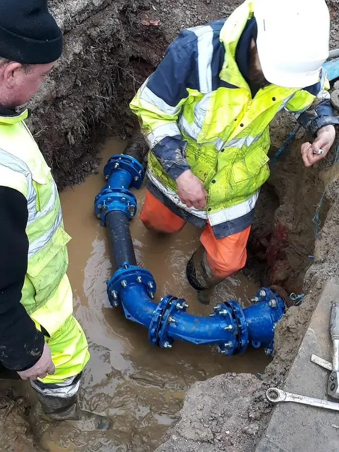 Équipes Ducrocq TP posant un raccord en fonte sur une canalisation d'eau potable