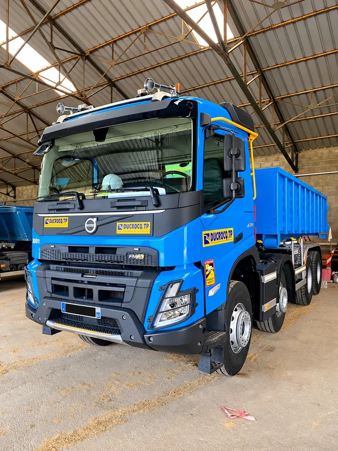 Camion porteur 8×4 Ducrocq TP stationné sous le hangar
