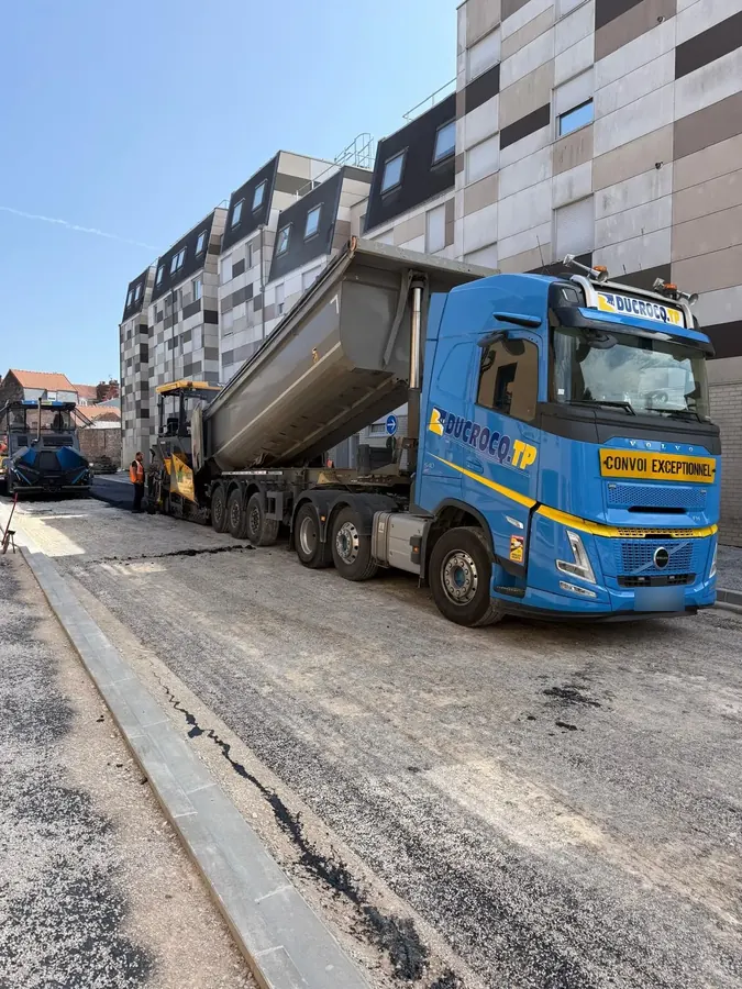 Semi-remorque benne Ducrocq TP alimentant le finisseur lors de l'application d'enrobés en ville