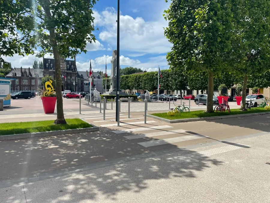 Centre-ville réaménagé : cheminements en béton désactivé, passage piéton, bordures, potelets et jardinières
